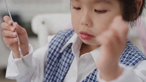 귀여운 아시아 소녀가 아침 식사를 하고 부 ⁇ 에서 시리얼을 즐기고 학교 유니폼을 입고 준비하고 있습니다.