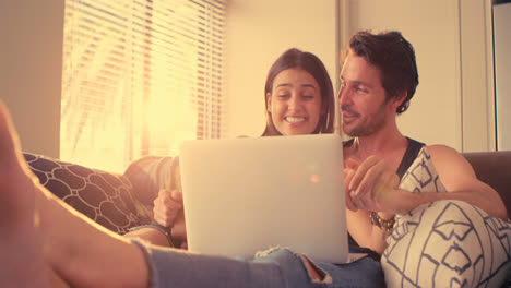 Couple-using-laptop-in-living-room-at-home-4k