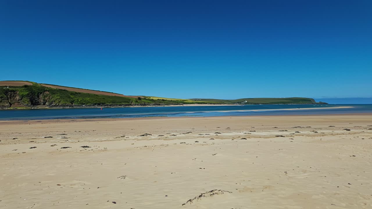 Pan from right to left of Daymer Bay beach and Padstow, Cornwall, UK