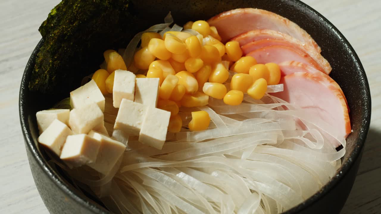 누들, 토푸, 옥수수, 햄 을 넣은 맛있는 아시아 수프 를 준비 하는 것