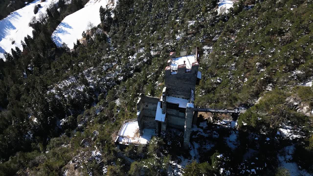 una antigua ruina de un castillo en una roca en las montañas en invierno