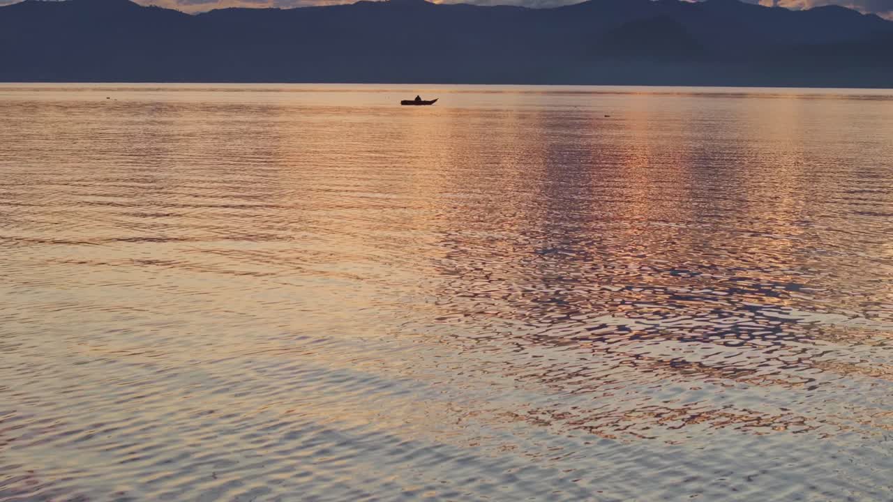 해가 뜨는 동안 시 보트와 함께 과테말라의 아란 호수 사진을 공개합니다.