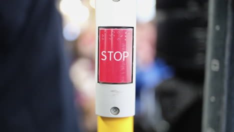 stop button in a bus with passengers in blurry background