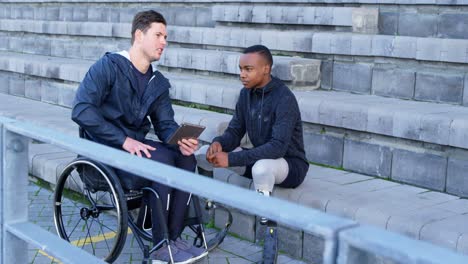 two disabled athletics discussing over digital tablet 4k