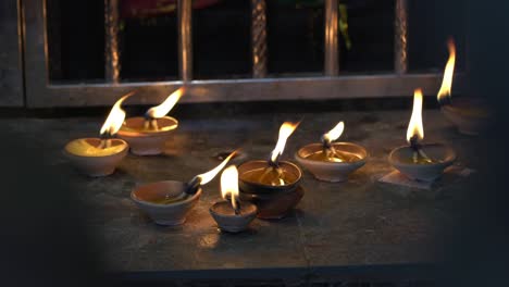 burning diyas oil lamp on an altar inside a hindu temple.