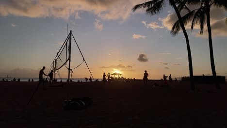 lapso de tiempo de la puesta de sol de waikiki con voleibol jugando en silueta