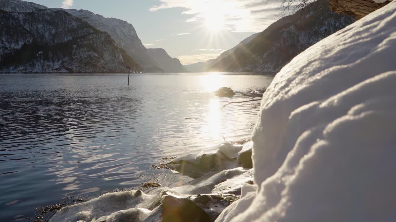 En snötäckt förgrund avslöjar en klar vinterdag med en fantastisk utsikt över Veafjorden i västra Norge. Kameran glider långsamt åt vänster.