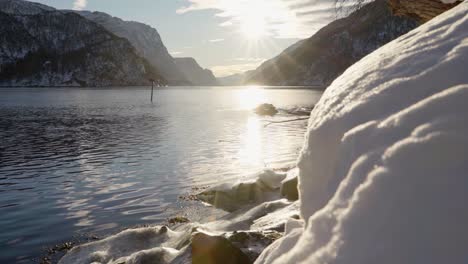 A snowy foreground reveals a clear winter day with a stunning view of Veafjorden fjord in western Norway. Camera slides slowly to the left