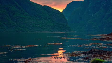 time lapse shot of cruise liner cruising on norwegian fjord water between mountains during sunset - 5k timelapse