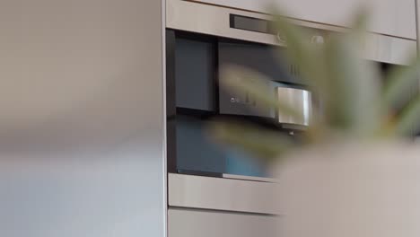 slow orbiting shot of a drinks dispenser integrated into a refrigerator in a kitchen