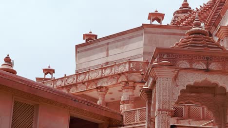 artistic-hand-carved-red-stone-jain-temple-at-morning-from-unique-angle-video-is-taken-at-Shri-Digamber-Jain-Gyanoday-Tirth-Kshetra,-Nareli-Jain-Mandir,-Ajmer,-Rajasthan,-India