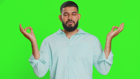 indian man meditating breathes deeply with mudra yoga gesture eyes closed taking a break relax