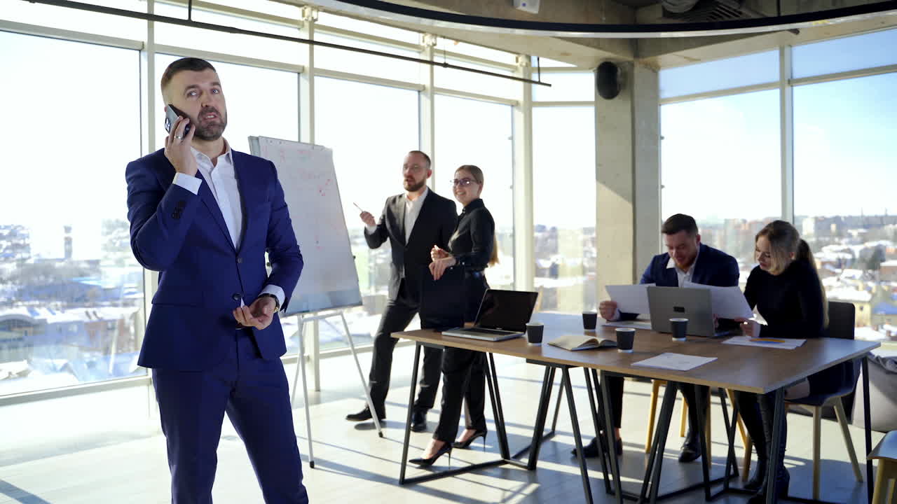Business people in office. Young entrepreneurs working at new projects. Successful businessman in suit talking the phone.