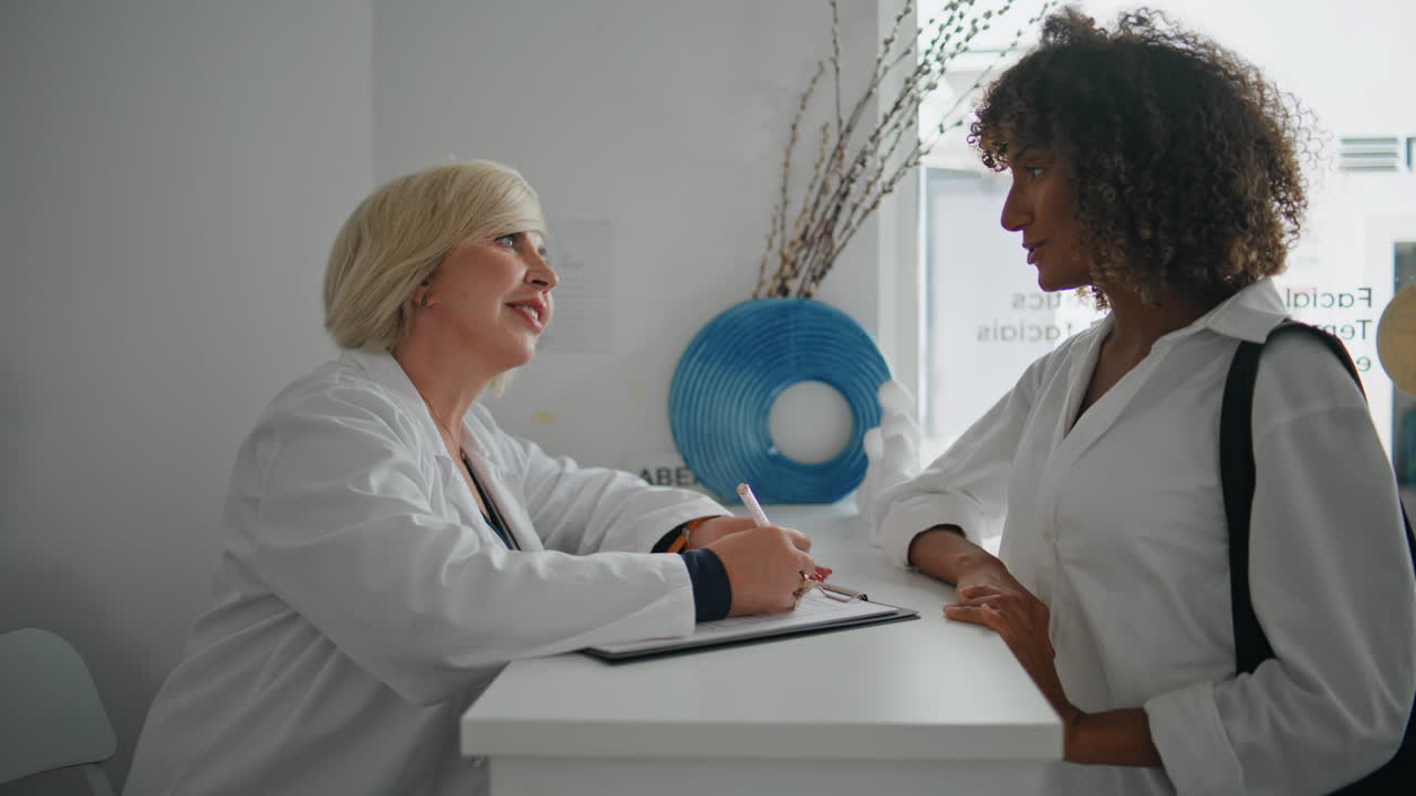 Smiling nurse talking client at reception desk closeup.Patient visit clinic