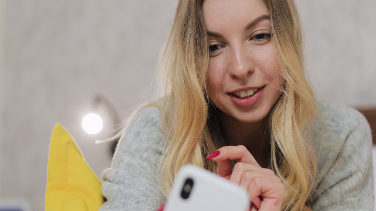 mujer usando teléfono inteligente en la cama