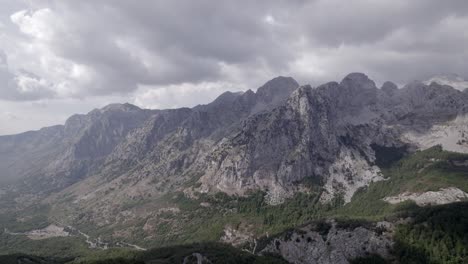 Frontales-Drohnenvideo,-Das-Sich-über-Den-Lumi-I-Thethit-Fluss-Im-Theth-Tal,-Albanien,-Bewegt,-Mit-Den-Bergen-Im-Vordergrund-Als-Hauptaufnahme