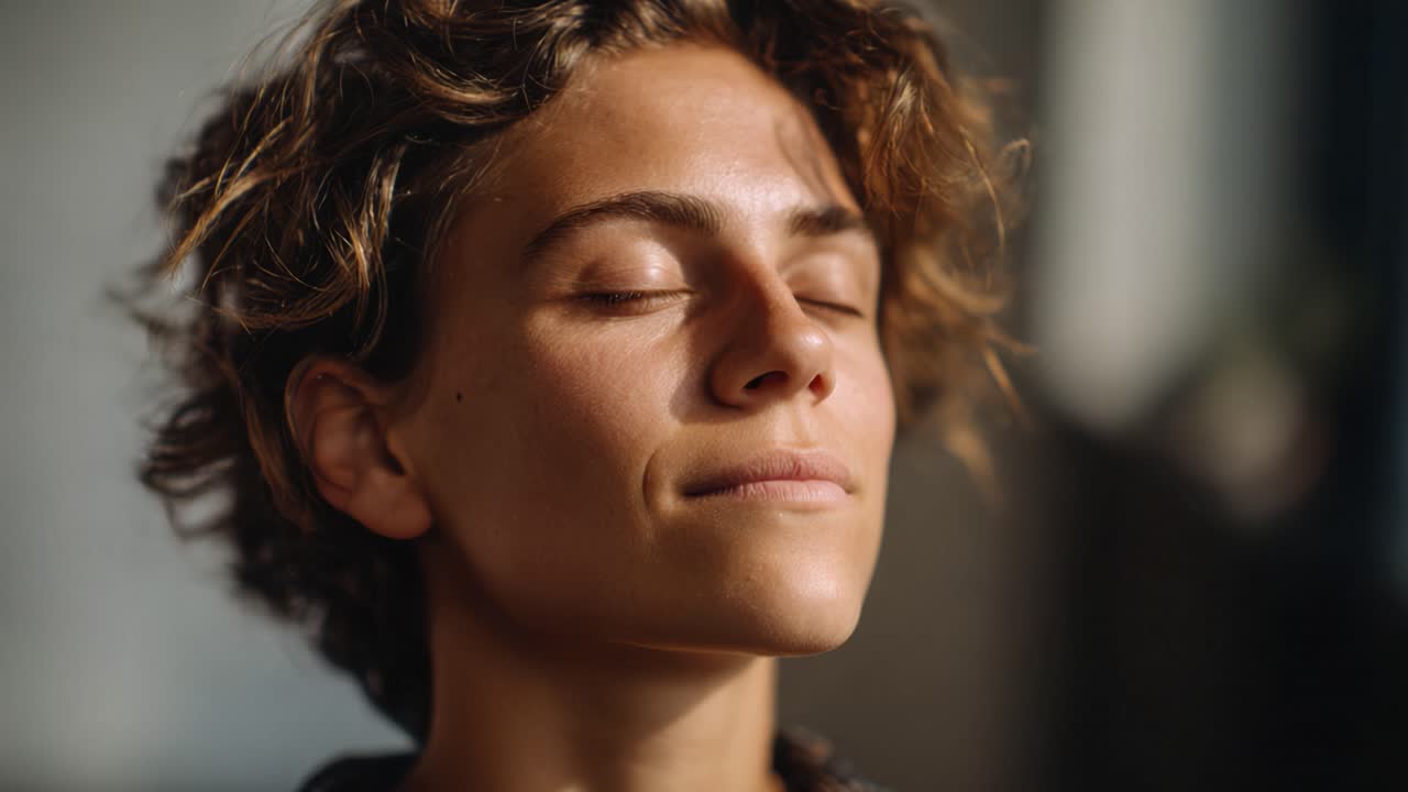 Un momento sereno di rilassamento tranquillo: Primo piano di una persona con capelli ricci che si gode la quiete e la tranquillità in un ambiente illuminato da luce soffusa.