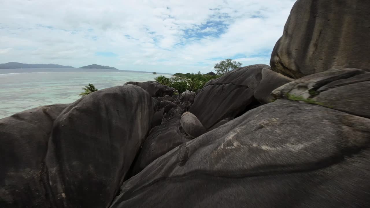 Fpv drone flying on a Anse Source d'Argent beach in Seychelles on an Island Mahe, video of incredible trees, Seychelles rocks, seaside, and surrounding Seychelles landscapes