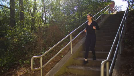 an athlete enters a small park by way of concrete stairs in order to take advantage of a lovely day outdoors running and exercising