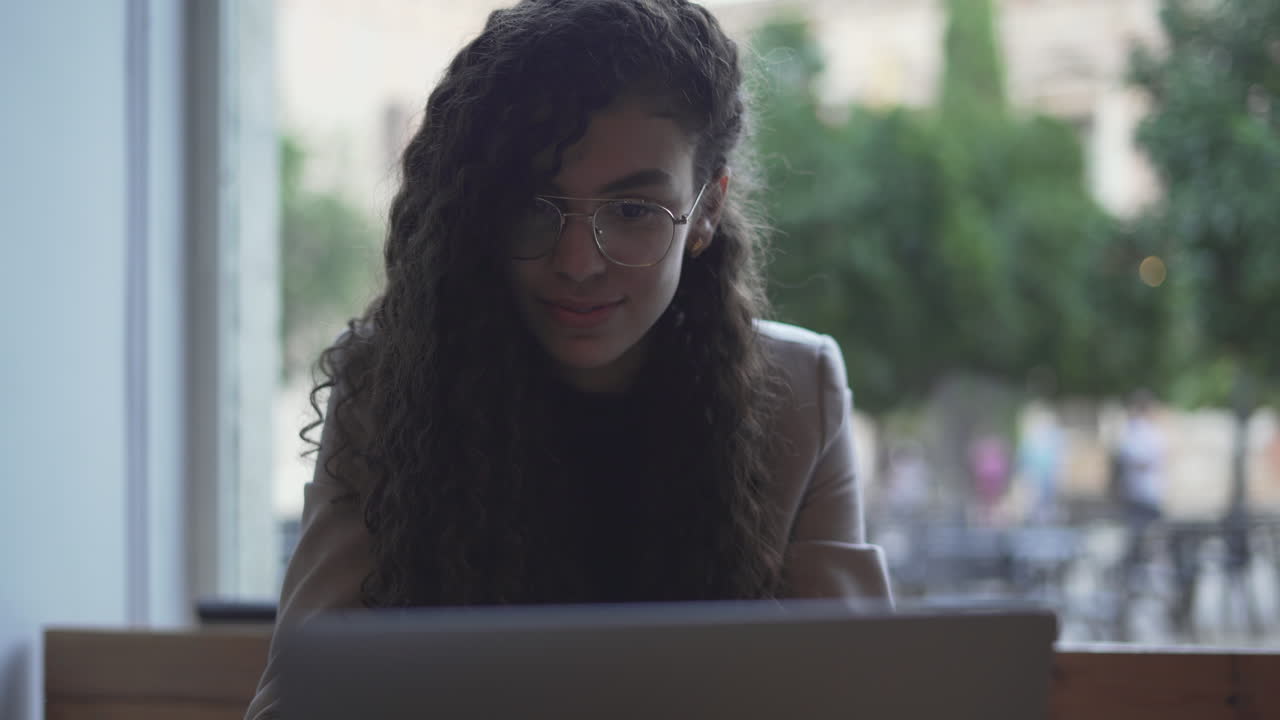 Young woman working on laptop in a cafe