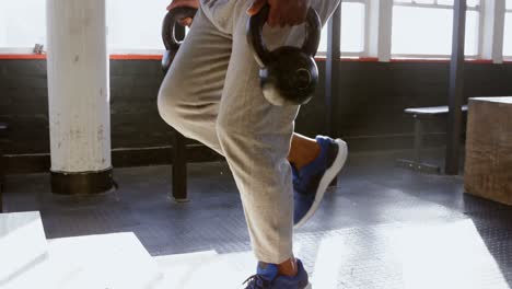 Senior-man-exercising-with-kettle-bell-in-the-fitness-studio-4k