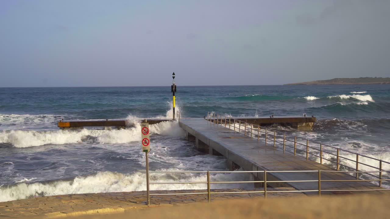 큰 물보라와 함께 마요르카의 돌 피어에서 부서지는 파도