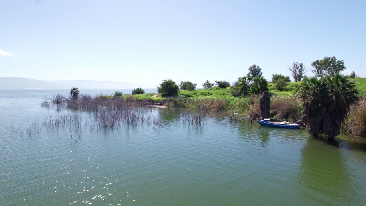 palomas cruzando el marco con un barco en el fondo en la orilla de los mares de galilea