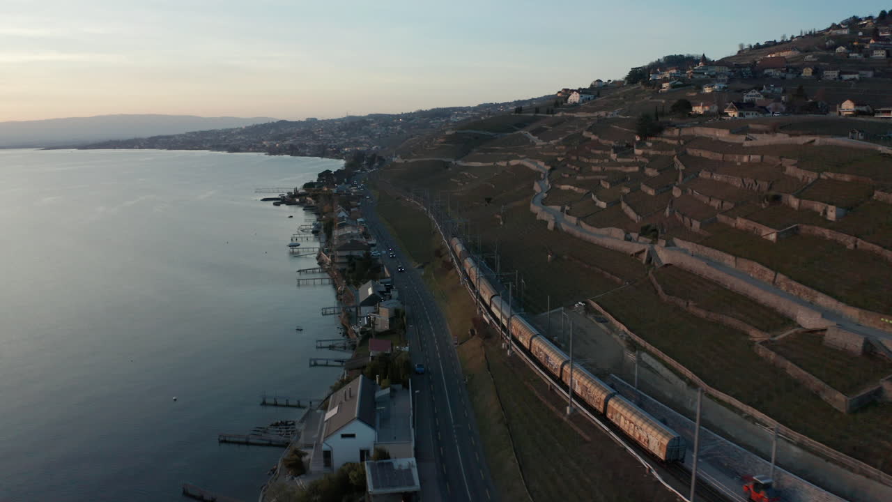 antena del tren de carga pasando por la autopista cerca del hermoso lago