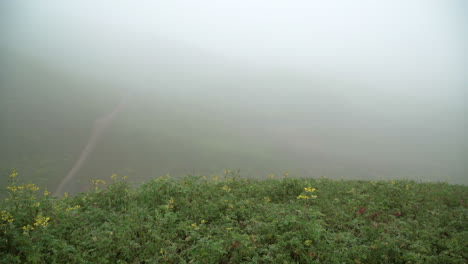 Panning-left-to-right-shot-during-a-foggy-morning,-off-the-summit-of-a-hill-in-Lomas-de-Manzano,-Pachacamac,-Lima,-Peru