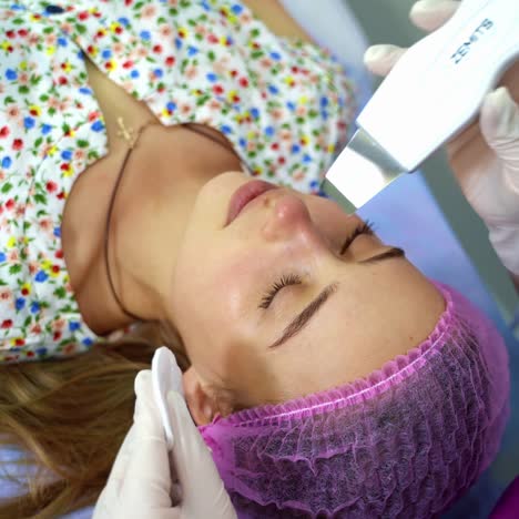 doctor with ultrasonic scraber. procedure of ultrasonic cleaning of face. patient in beauty clinic. healthcare, clinic, cosmetology. video from the top