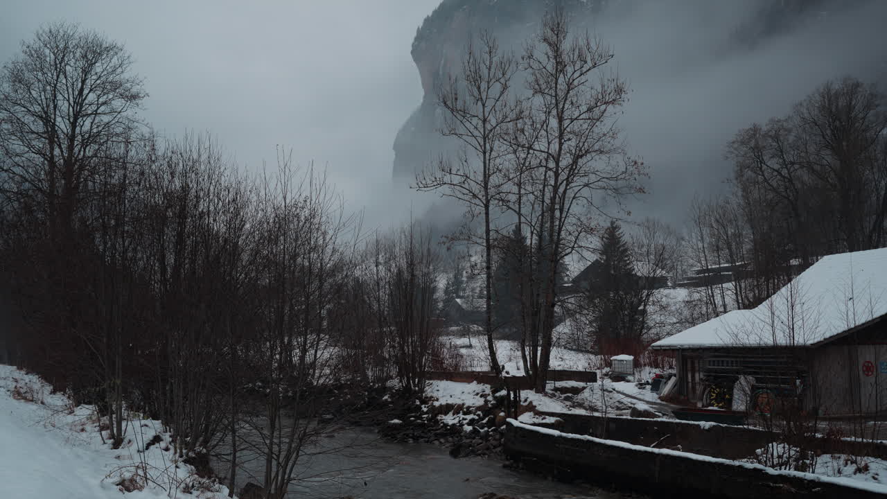 Serene view of the Weisse L&uuml;tschine river in Lauterbrunnen, Switzerland, captured on a tranquil, snowy winter day, showcasing the ethereal beauty of nature