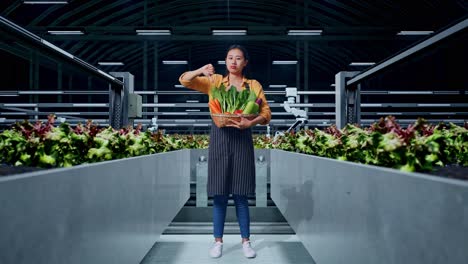 full body of asian female farmer with vegetable basket showing thumbs down gesture while standing in smart farm