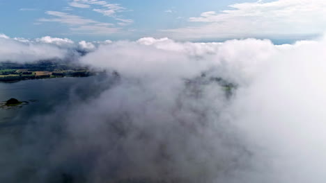 a flight above the clouds reveals pieces of land and water surface