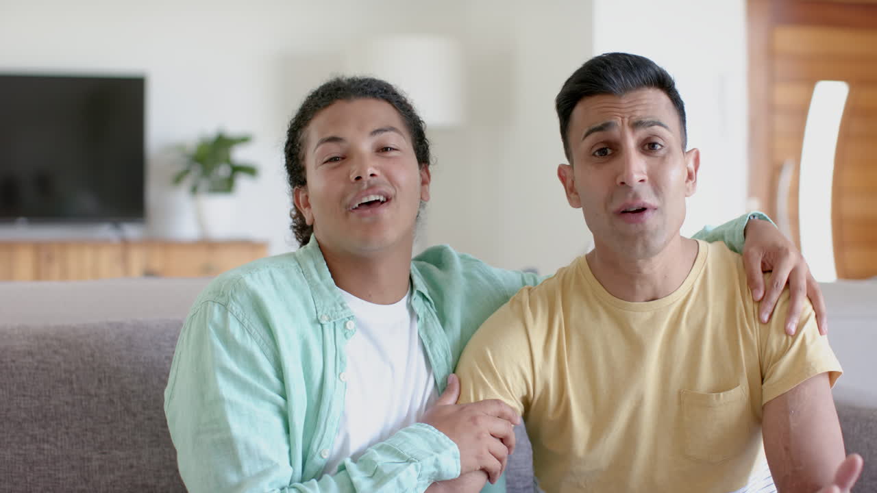 다양한 행복한 동성애자 남성 커플이 비디오 통화를 하고, 집에서 포옹하고 이야기하고, 느린 동작