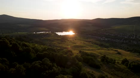 sunlight reflects off pond amidst rolling hills, varbo, hungary