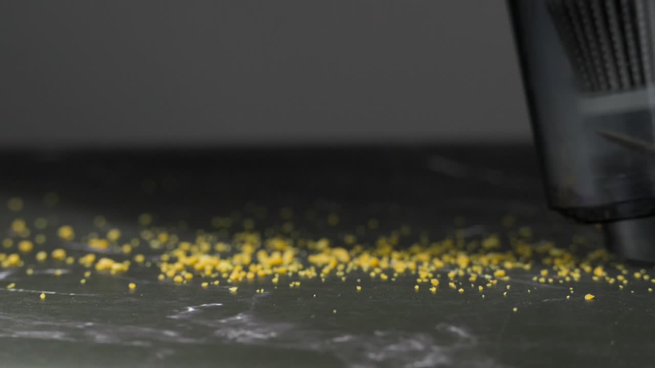 Close-up of a Vacuum Cleaner Cleaning Up Yellow Dust Particles