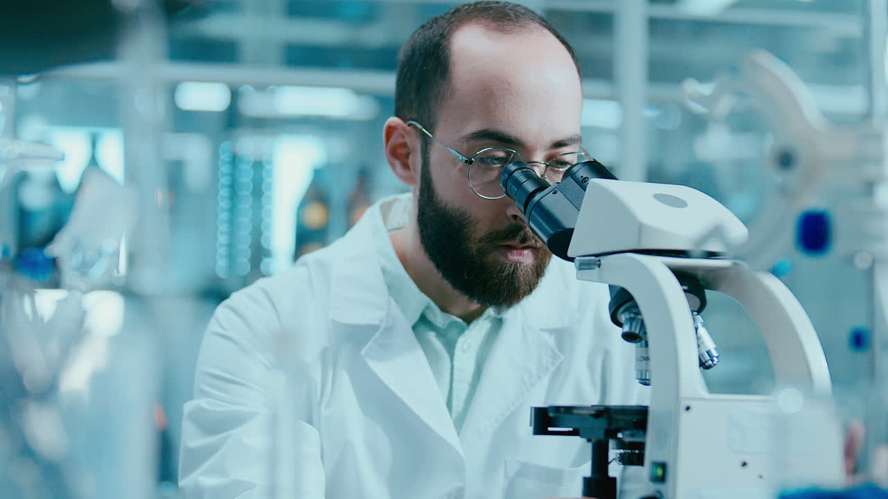 Male Scientist Performing Microscopic Research in Laboratory
