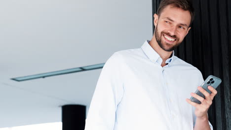 hombre de negocios usando un teléfono inteligente en un entorno de oficina moderno