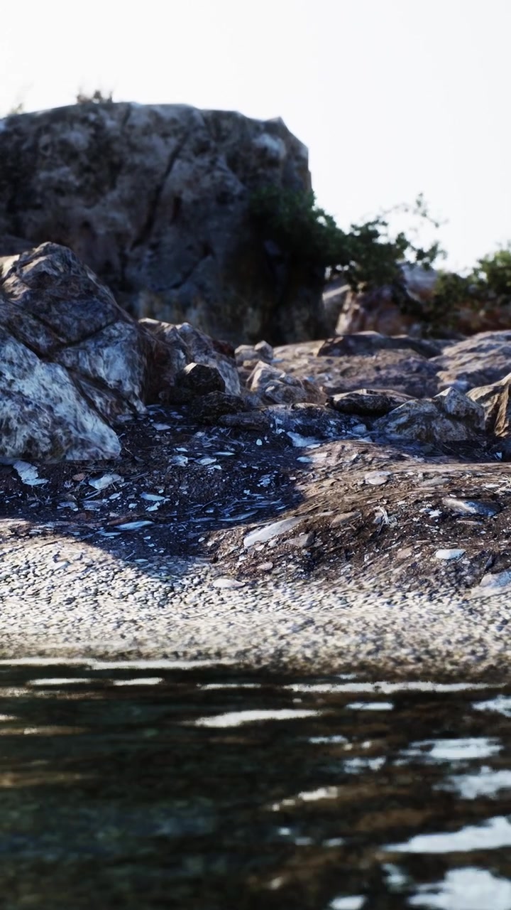 Costa rocciosa con l'acqua che riflette la luce del sole in un ambiente naturale.