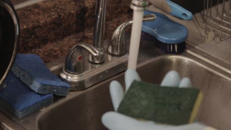 Putting-A-Small-Amount-Of-Dishwashing-Liquid-On-A-Sponge-And-Wet-It-With-Water---Close-Up-Shot