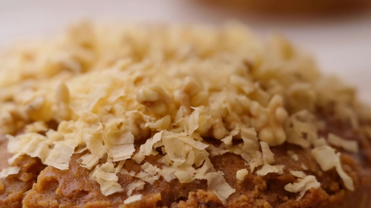 A close-up macro shot of oatmeal in a bowl, set against a neutral beige background, capturing the essence of healthy eating and natural food preparation. The clean and bright setting comple.
