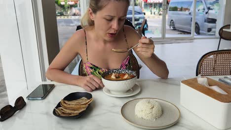 woman enjoying a delicious tom yum soup