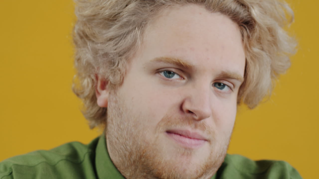 Man with Blonde Hair, Green Shirt, and Yellow Background