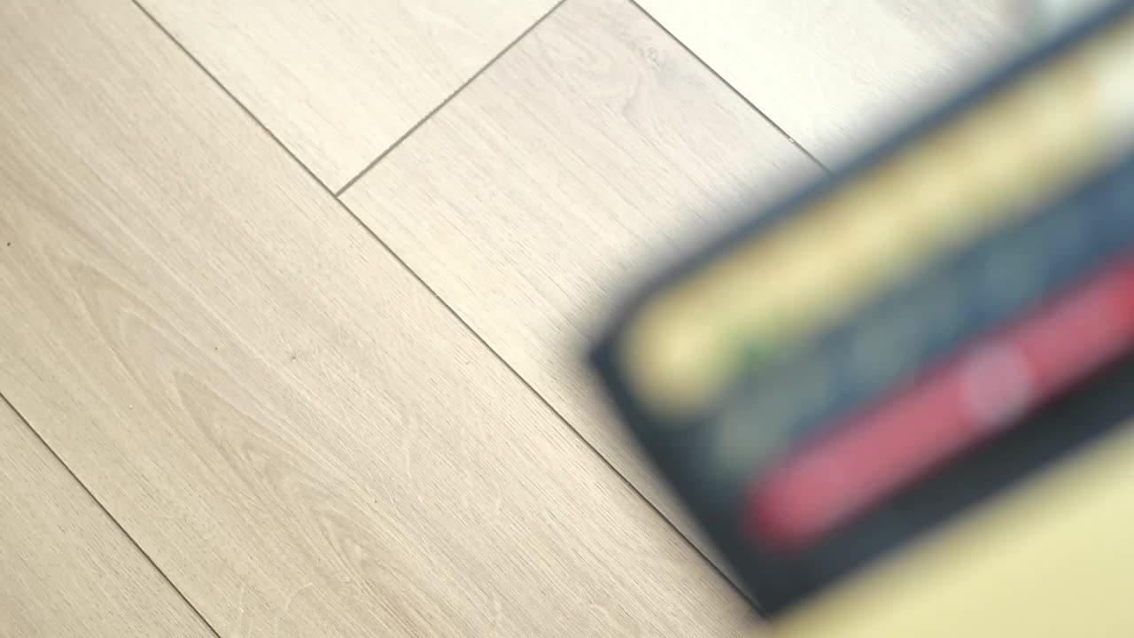 A person dropping a credit card on a wooden floor near a wallet