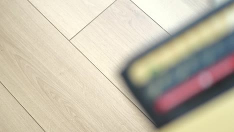 a person dropping a credit card on a wooden floor near a wallet
