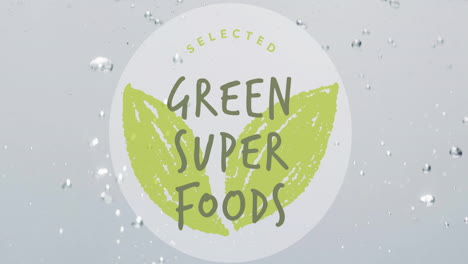 animación de súper alimentos verdes texto en círculo en la fruta que cae en el fondo del agua