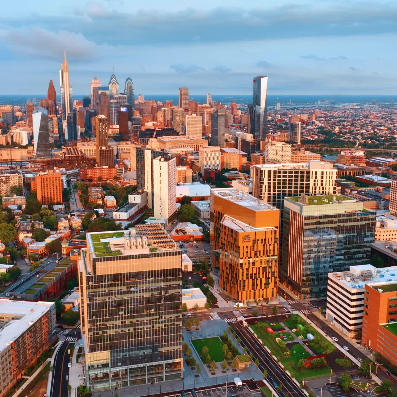 Buildings of Philadelphia downtown in the rays of setting sun. Bright cityscape of the city with skyscraper complex in the centre. Top view