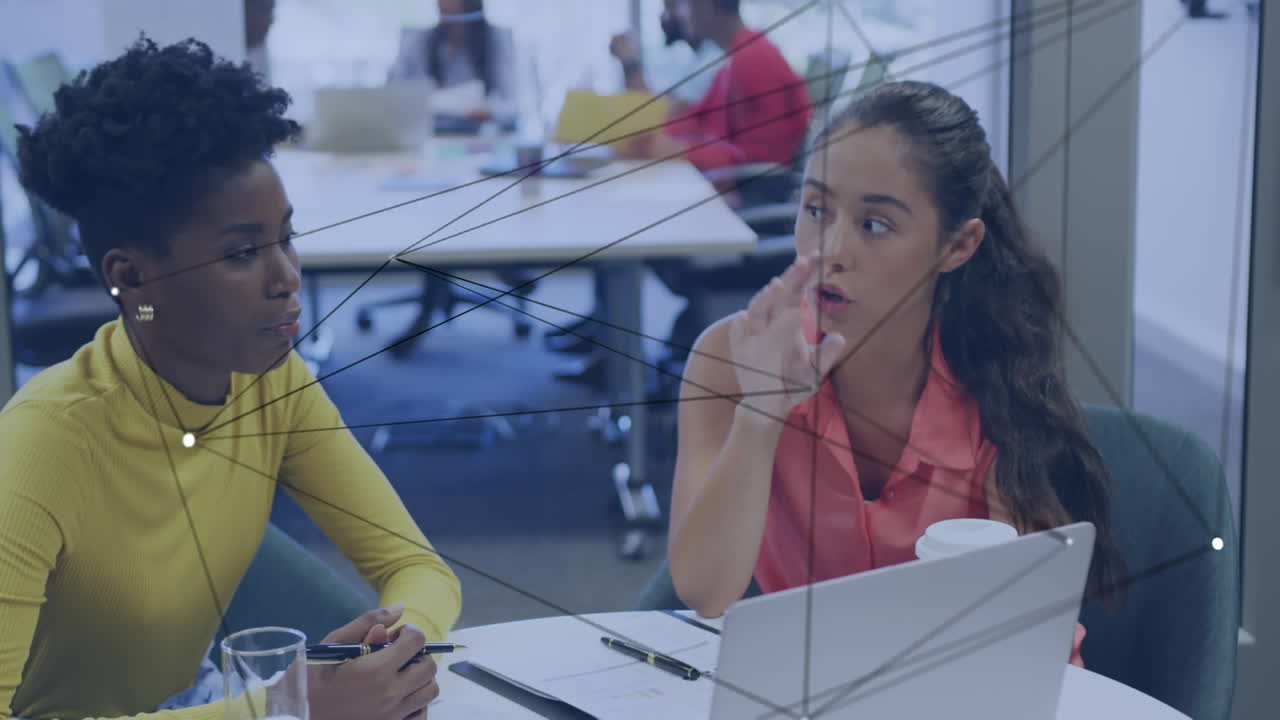 animación de puntos de conexión contra dos mujeres diversas discutiendo en una computadora portátil en la oficina.