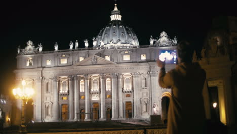 una mujer usando una tableta para capturar la basílica de san pedro.