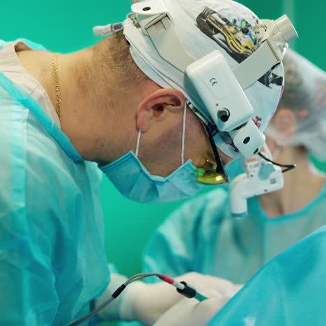 profesional doctor works with modern medical equipment. surgeon and a nurse in medical uniform and mask perform an operation in clinic.
